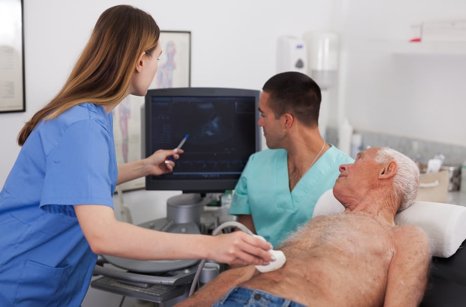 Two sonographers working with patient